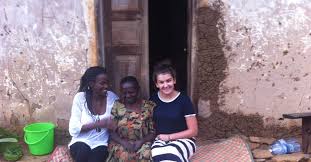 Community members and visitors sitting together outside a home during an outreach visit.
